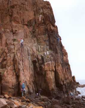 [View of climbers on The Hawkcraig sea cliff]